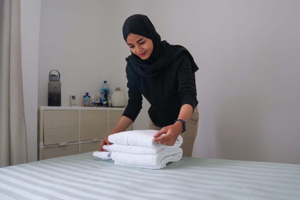 wanita muda sedang merapihkan handuk