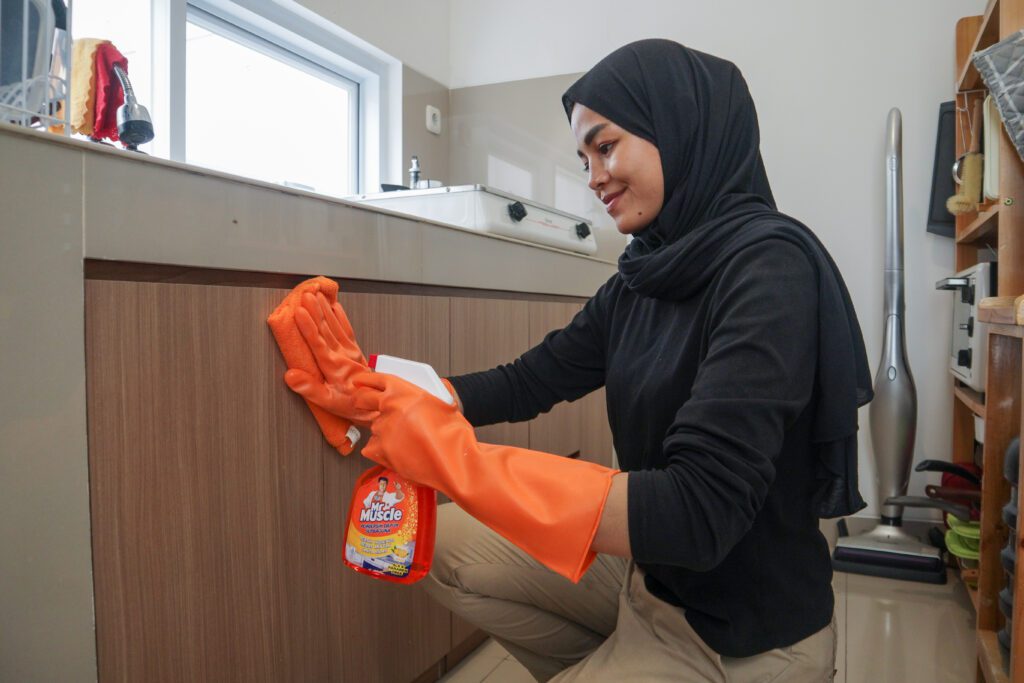 wanita muda sedang membersihkan dapur